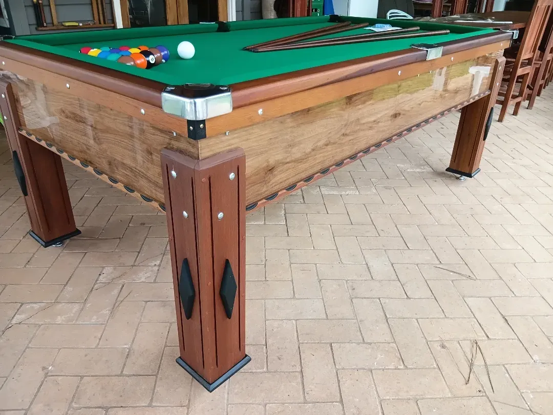 Mesa de bilhar profissional JHP Bilhares com pano verde, madeira escura, em varanda com vista rural.