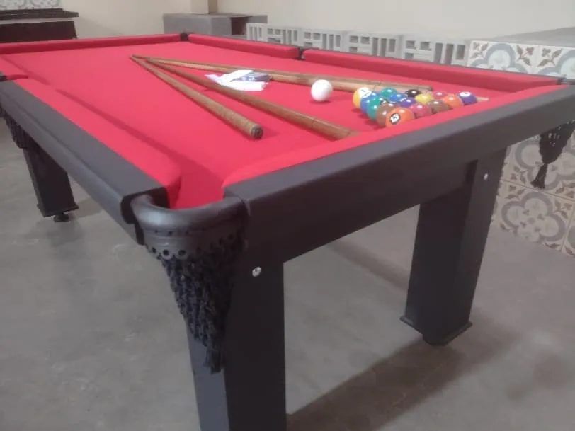Mesa de bilhar preta com pano vermelho, caçapa com rede e conjunto de bolas.